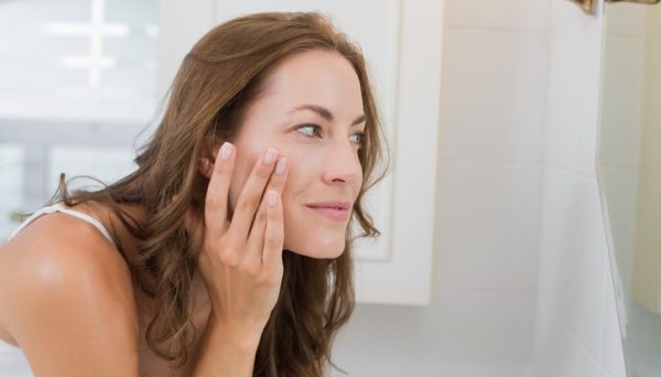 woman touching clear face on skin